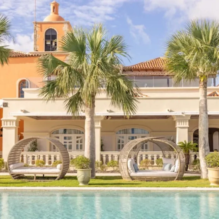 pool and cabanas and resort building at Sanctuary Cap Cana