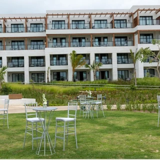 The Secrets Garden Lobby venue, a grassy lawn with cocktail tables in front of a hotel building.