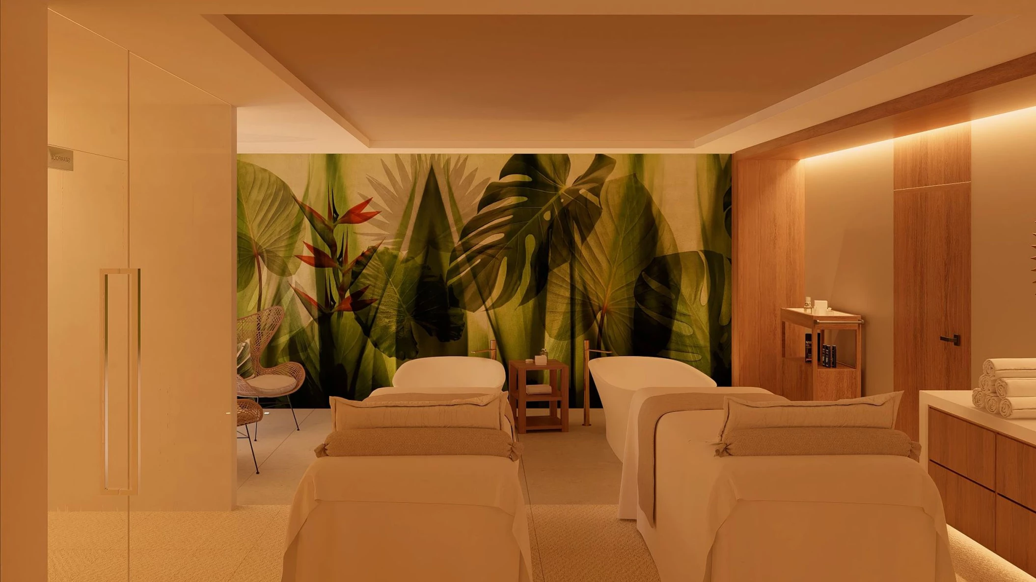 The interior of a spa massage cabin with two massage beds and a tropical leaf mural on the wall.