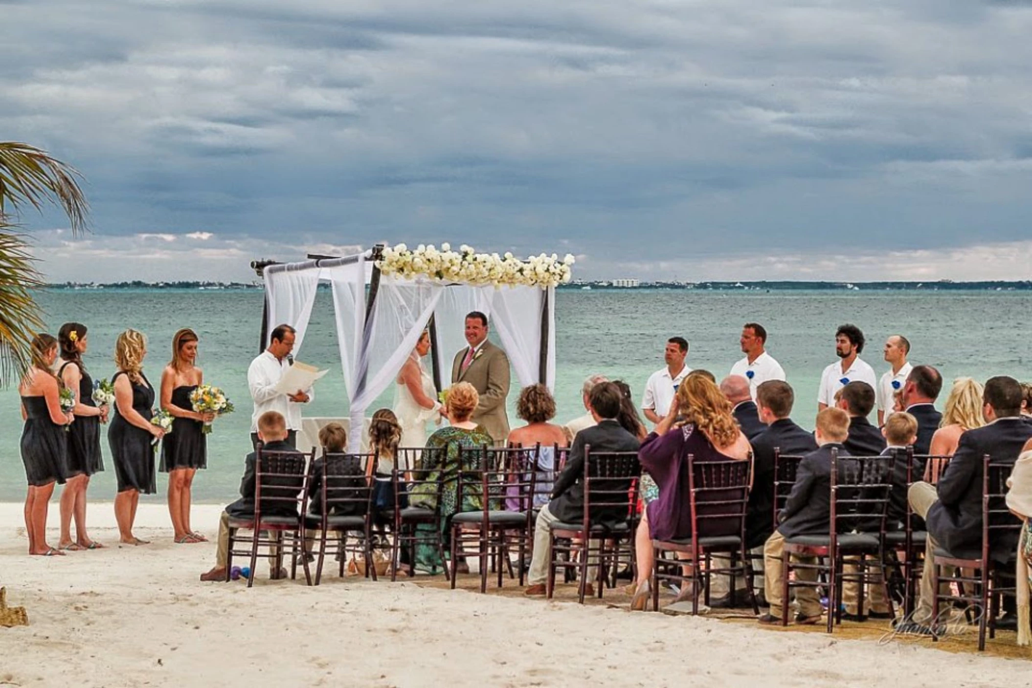 bride and groom and guests at the capricos beach venue ceremony at Villa del Palmar Cancun