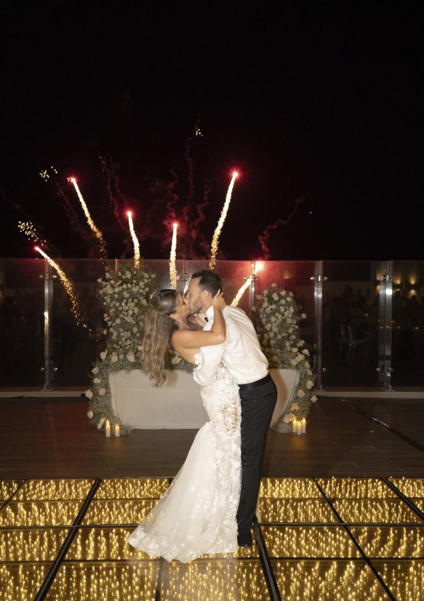 Andreana and Alessandro share a kiss during wedding fireworks