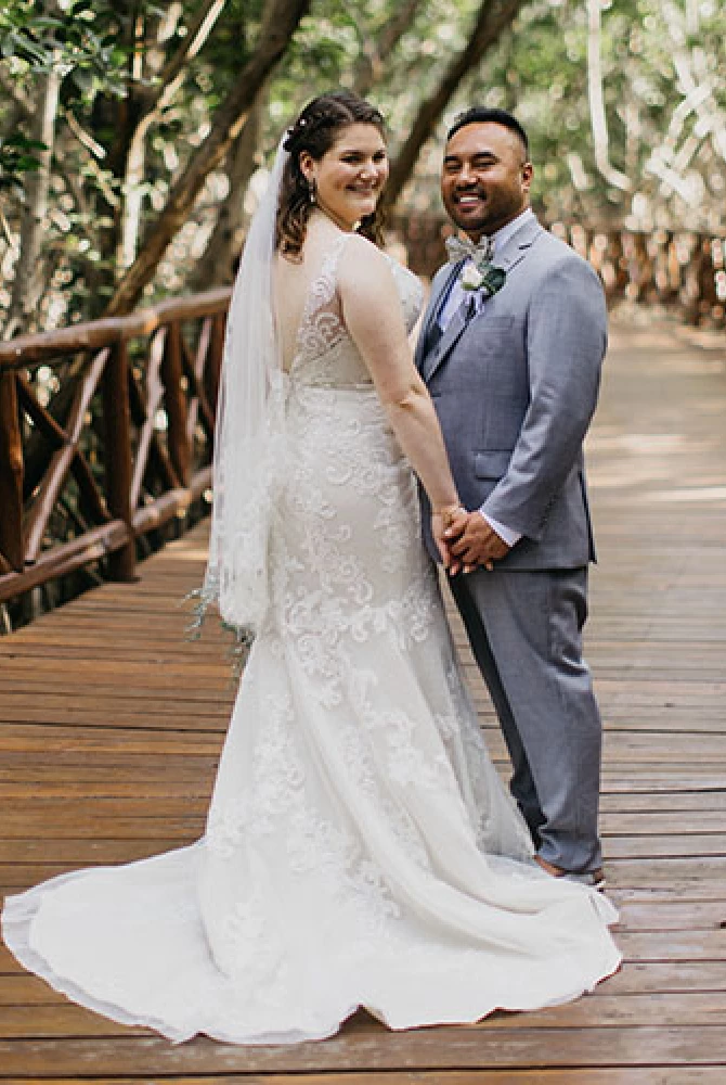 Couple posing for a shot on a wooden deck in the middle of the jungle