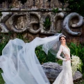 Beautiful bride poses at huge Xcaret sign.