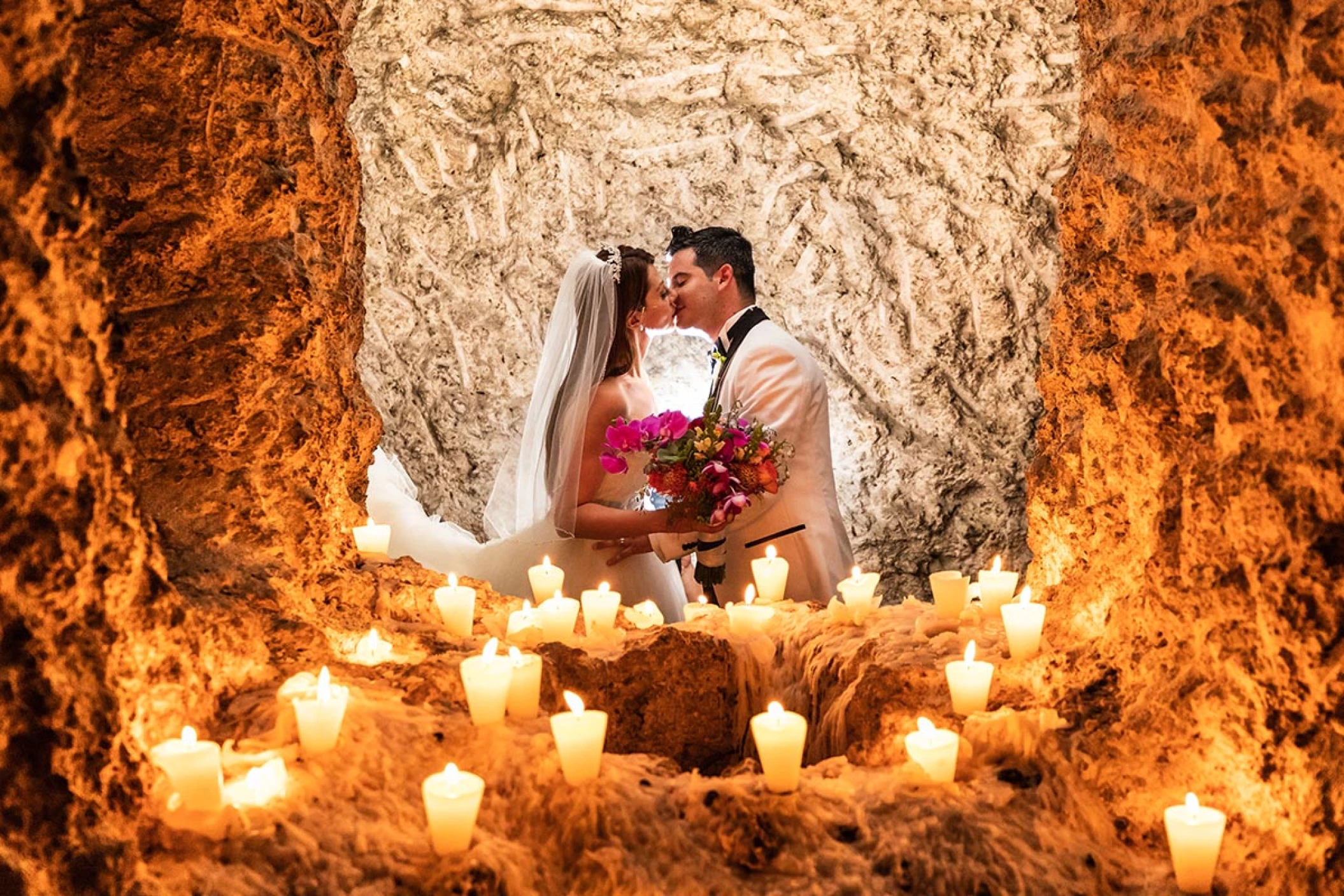 Couple kissing at the light of the candles.