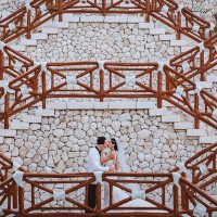 couple kisses at xcaret chapel stairway.