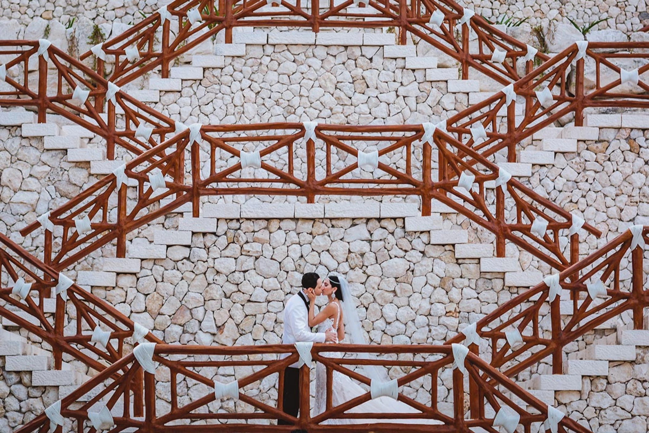 couple kisses at xcaret chapel stairway.