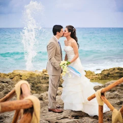 Just Married Couple kisses on a beautiful rocky beach.